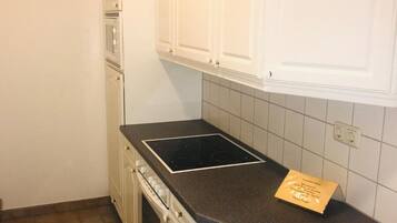Una cocina con armarios blancos, una encimera negra y un cartel en la encimera.