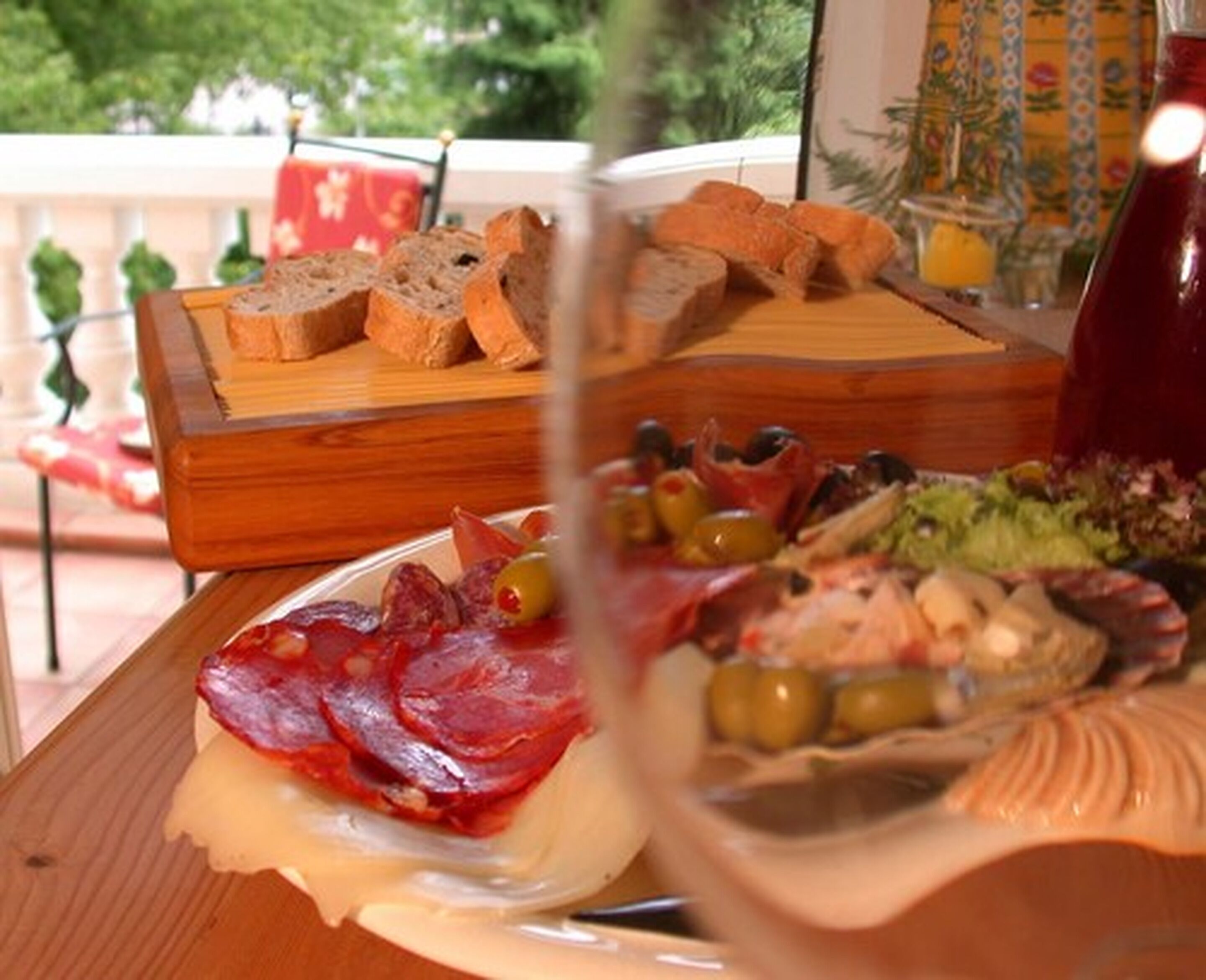 Ein Holzbrett mit verschiedenen Käsesorten, Oliven und Fleisch.