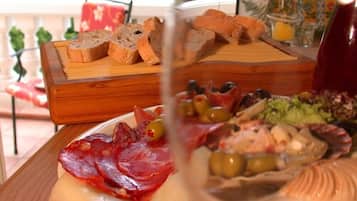 Ein Holzbrett mit verschiedenen Käsesorten, Oliven und Fleisch.