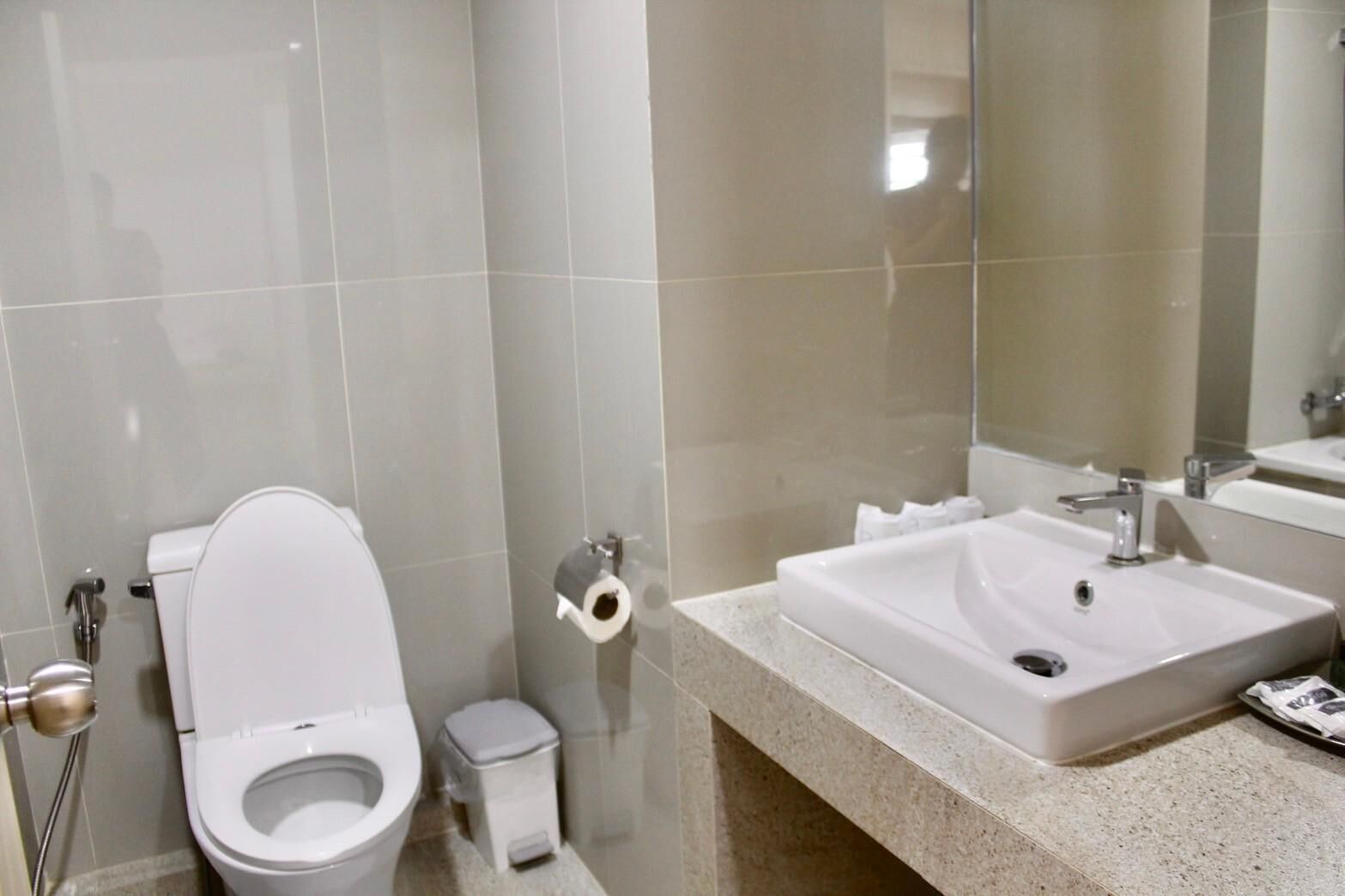 Ein modernes Badezimmer mit Toilette, Waschbecken und Spiegel.