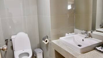 Ein modernes Badezimmer mit Toilette, Waschbecken und Spiegel.