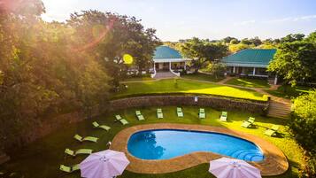 Relax by the pool surrounded by lush gardens and a serene atmosphere.