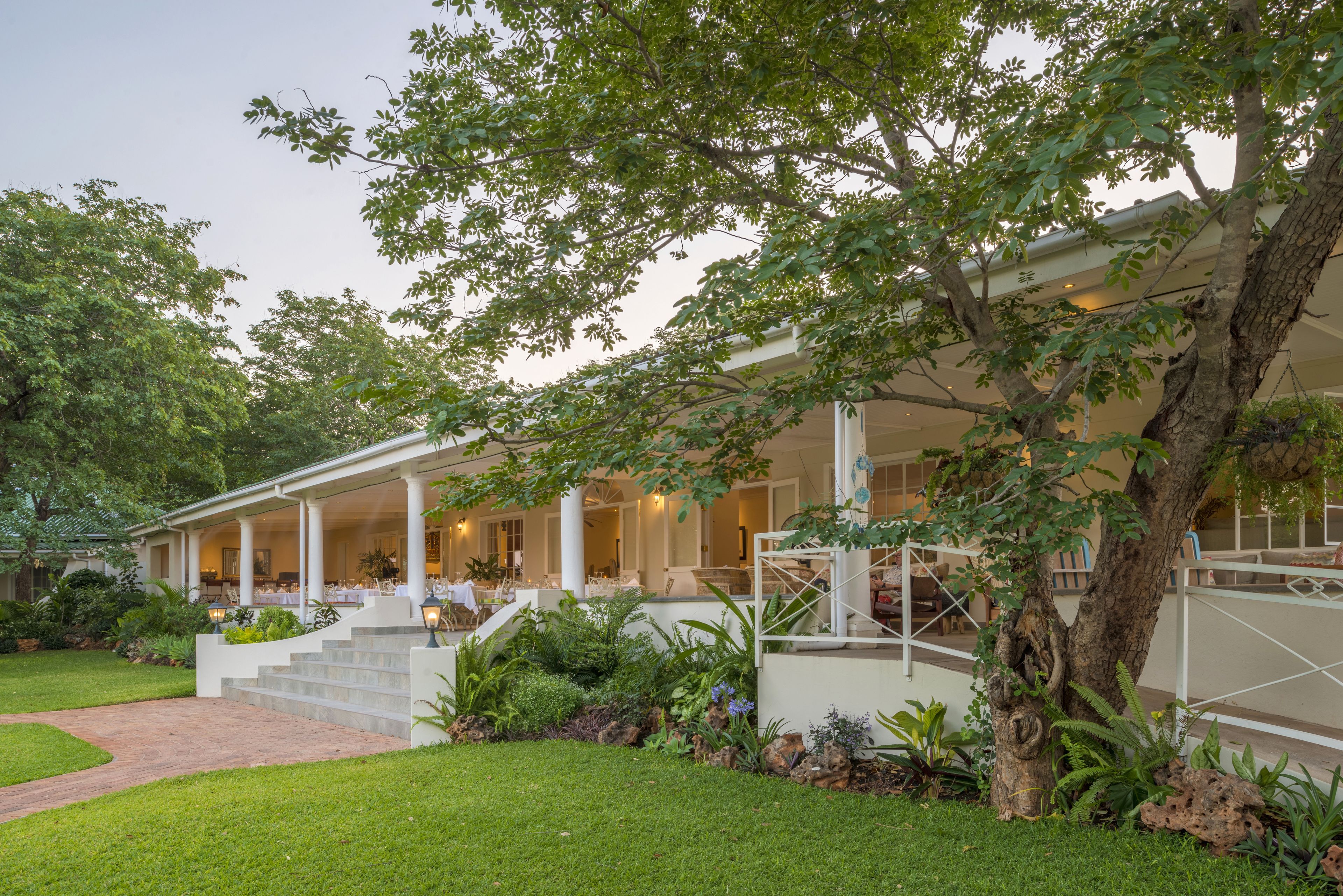A two-story building with a covered patio and a landscaped garden.
