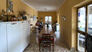 A kitchen with a long dining table, white cabinets, and a terrazzo floor. - Bed & Breakfast Cilento (San Mauro Cilento)