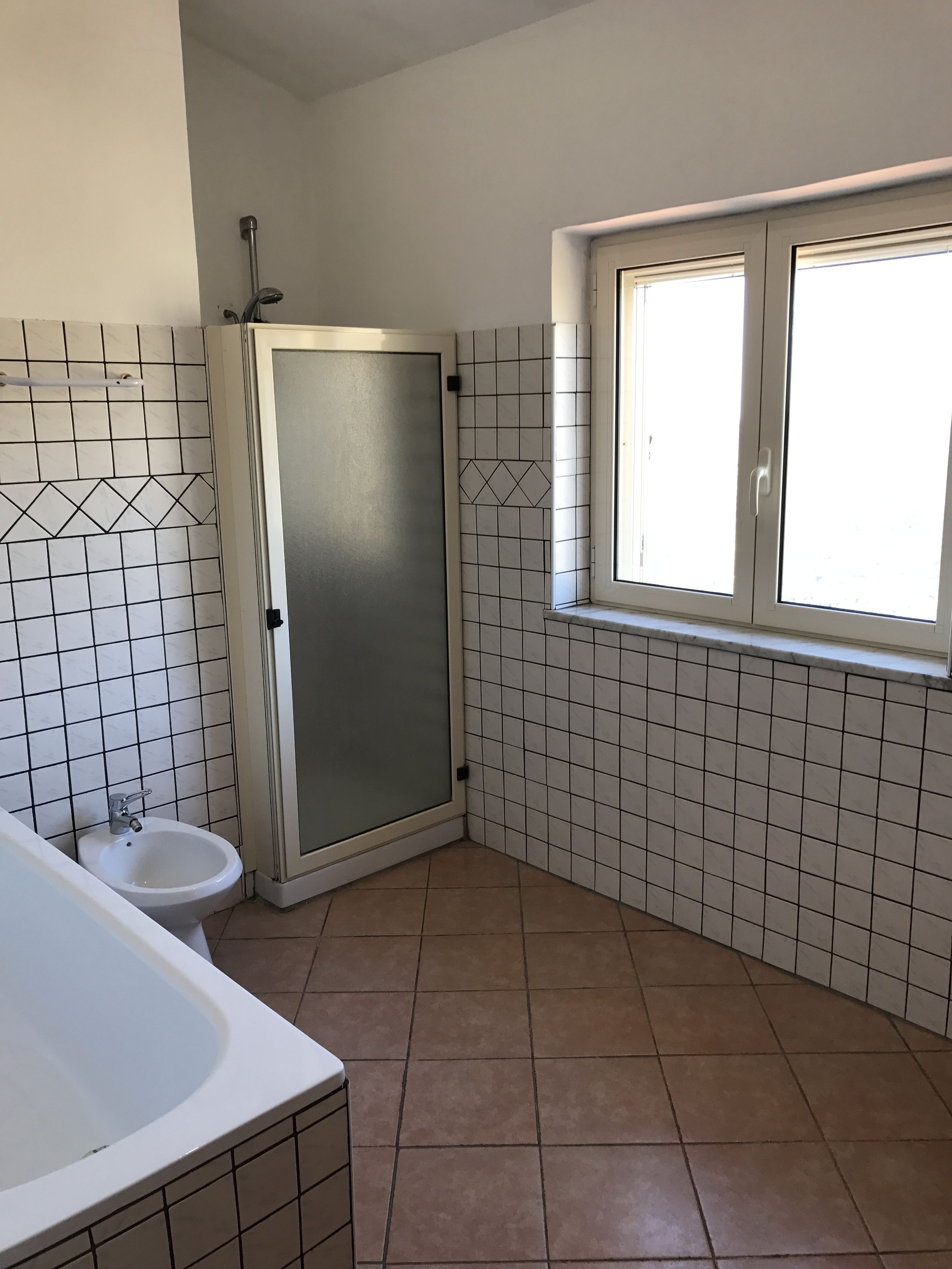 Ein Badezimmer mit Dusche, Toilette und Badewanne.