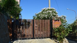 A gated entrance with a wooden fence, a stone pathway, and a sign for B&B Cilento. - Bed & Breakfast Cilento (San Mauro Cilento)