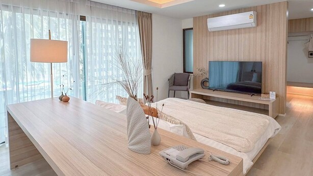Une chambre d’hôtel moderne équipée d’un grand lit, d’un bureau, d’une télévision et d’un appareil de climatisation.