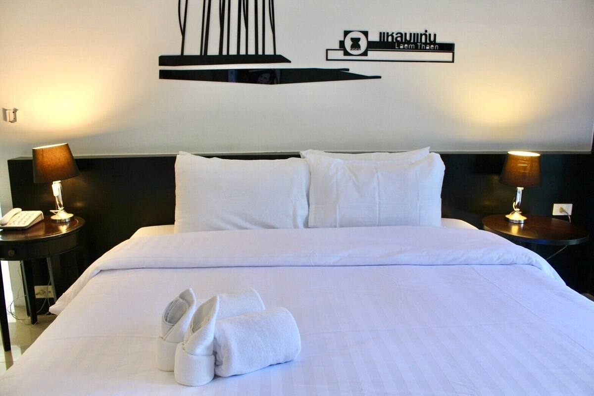 A hotel room with a neatly made bed, two bedside tables with lamps, and a wall decoration.