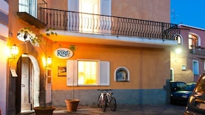 A building with a sign that reads "RING" and a balcony with a railing. - Ring Hostel (Forio)