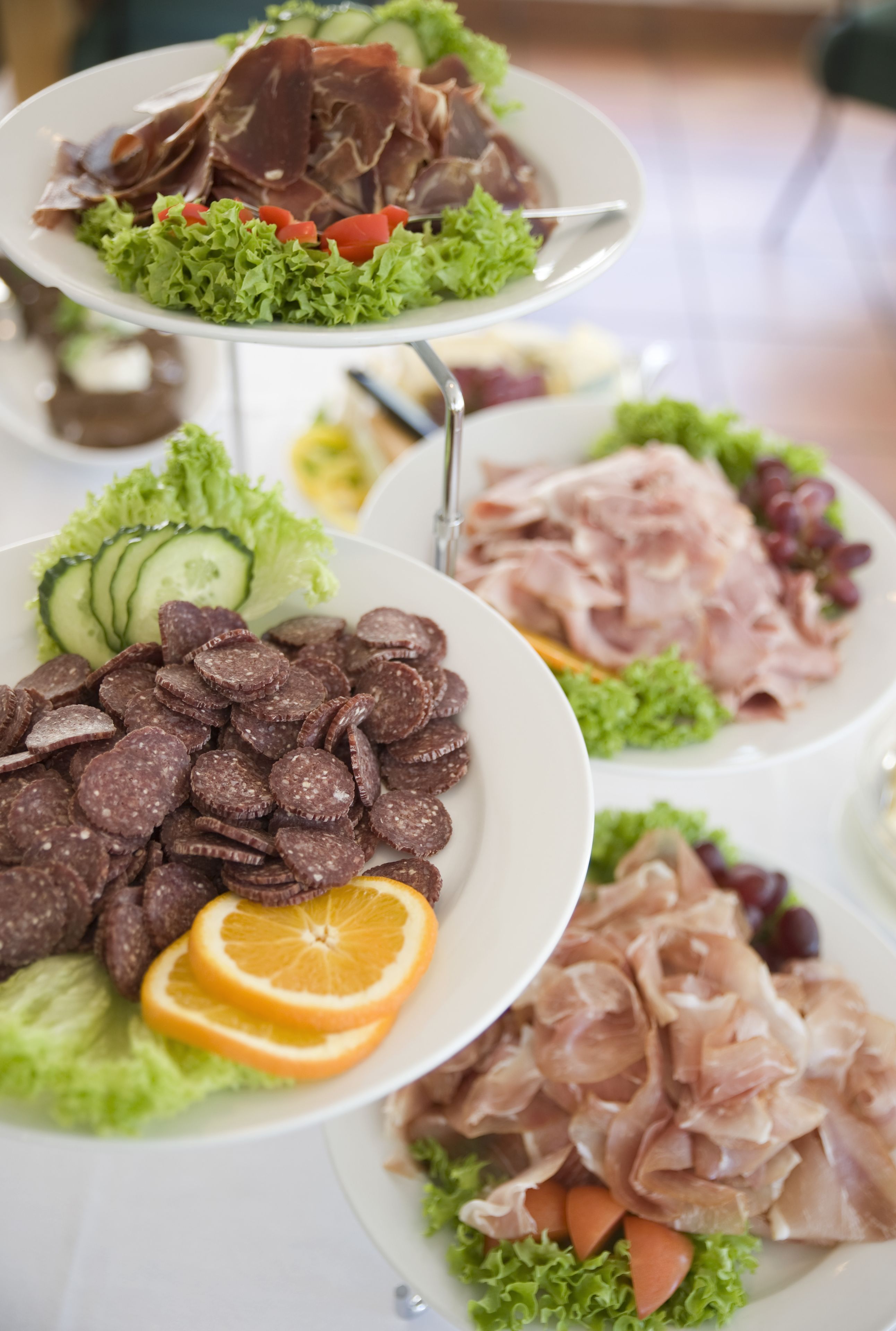 Une présentation gastronomique à plusieurs niveaux, comprenant divers plats, notamment des viandes tranchées, des légumes et des accompagnements.