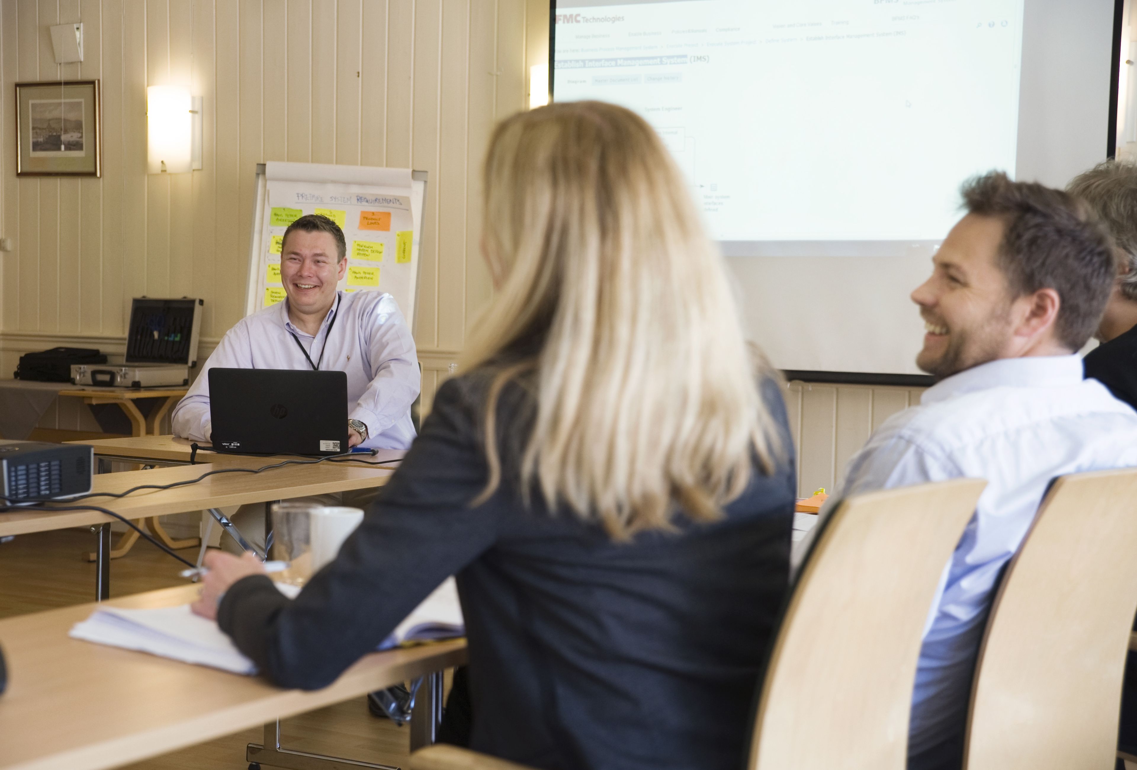 A conference room with a whiteboard, a laptop, and a projector.