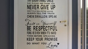 Una puerta con una cita motivacional sobre normas del hogar y respeto.