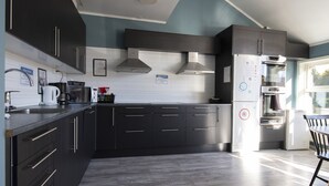 Una cocina moderna con armarios oscuros, electrodomésticos de acero inoxidable y salpicadero de azulejos.