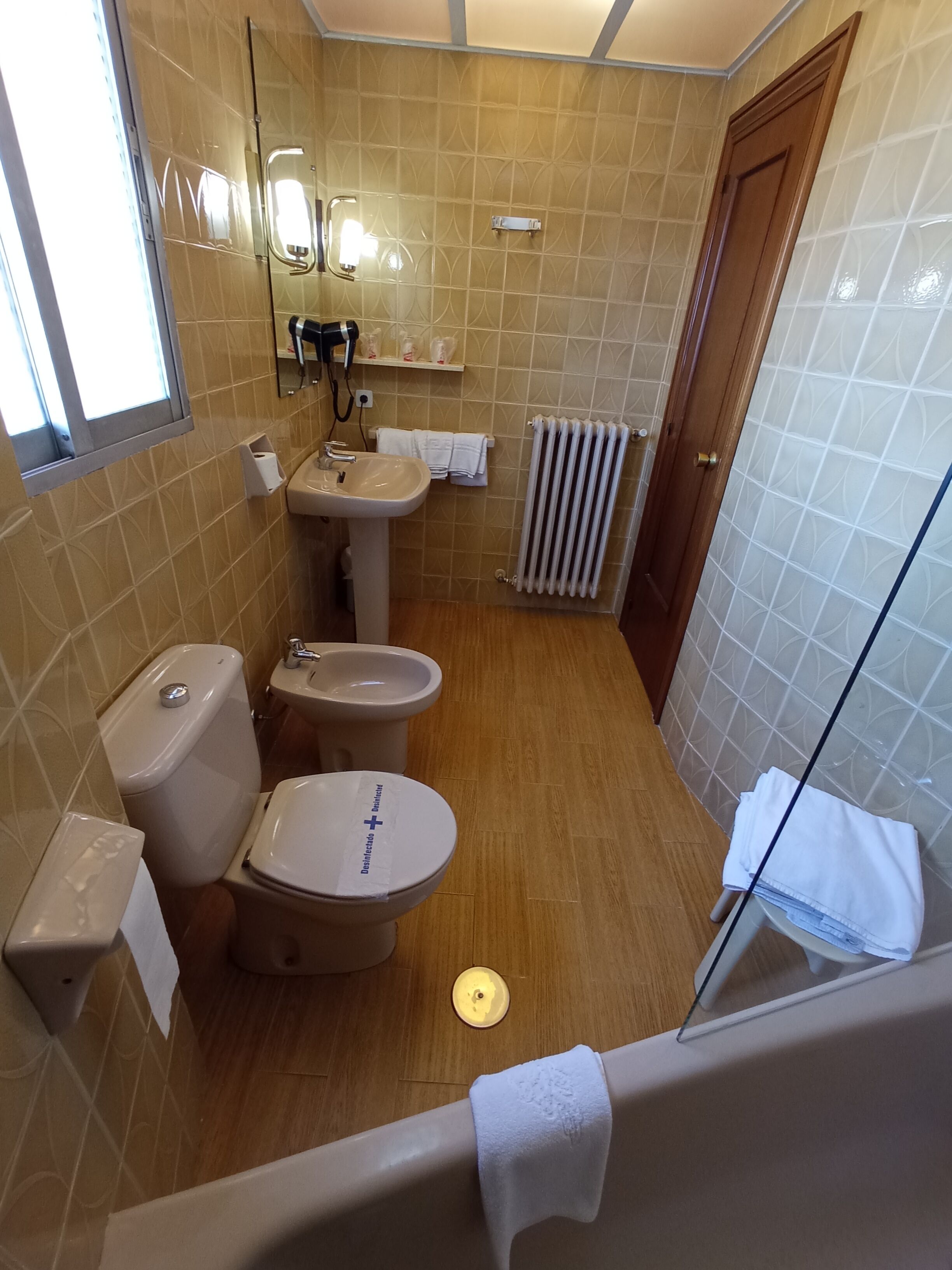 A bathroom with a toilet, bidet, sink, and bathtub.