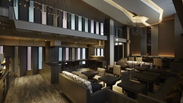 A modern hotel lobby with a mezzanine level, seating areas, and a bar. - At Home Hotel Ximen (Taipei)
