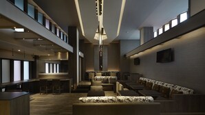 A modern interior with a bar area, seating, and a staircase. - At Home Hotel Ximen (Taipei)