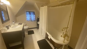 Un baño con lavamanos, inodoro y bañera con cabezal de ducha dorado.
