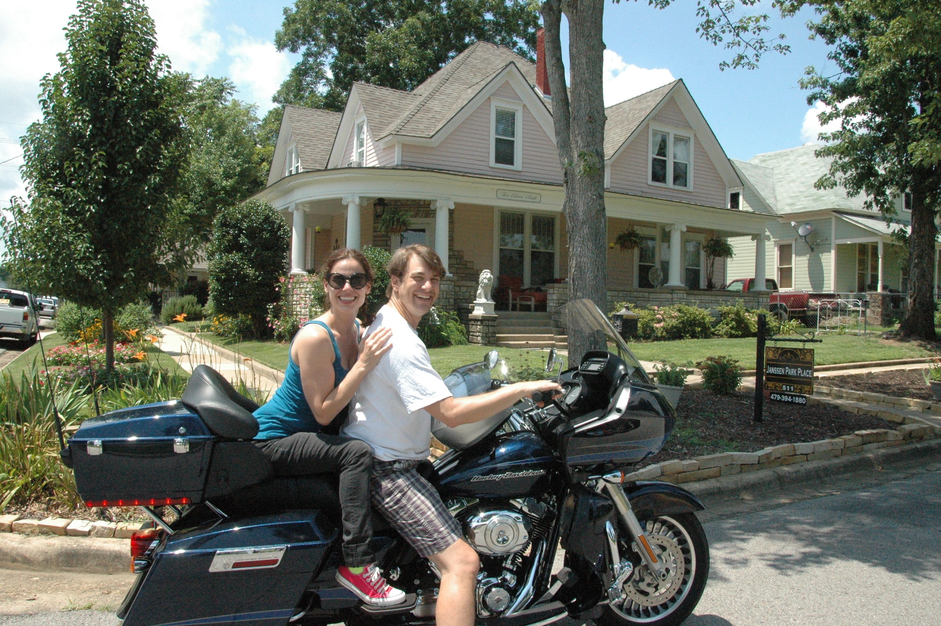 A two-story house with a porch, a mailbox, and a street view.