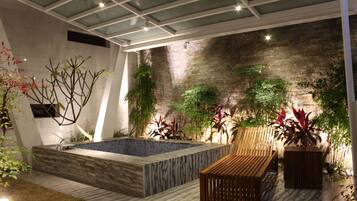 A modern indoor pool area with a wooden bench and potted plants.