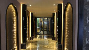 A corridor with reflective floors and walls, leading to a glass door entrance. - All-Ur Boutique Motel - Yi-Lan Branch (Yilan)