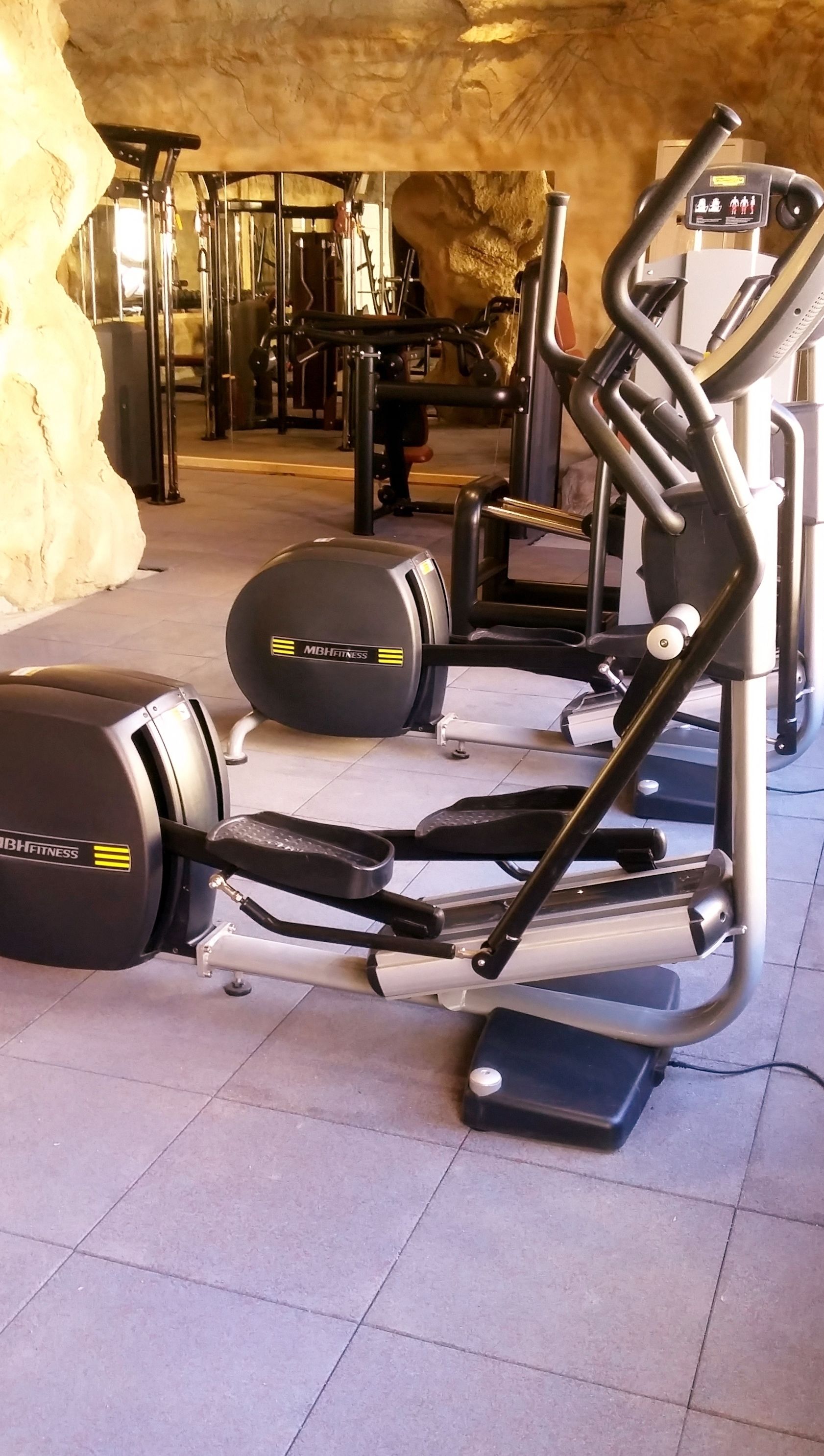A gym with treadmills, elliptical machines, and weightlifting equipment.