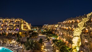 Een resort met meerdere gebouwen, een zwembad en een rotsachtig landschap.
