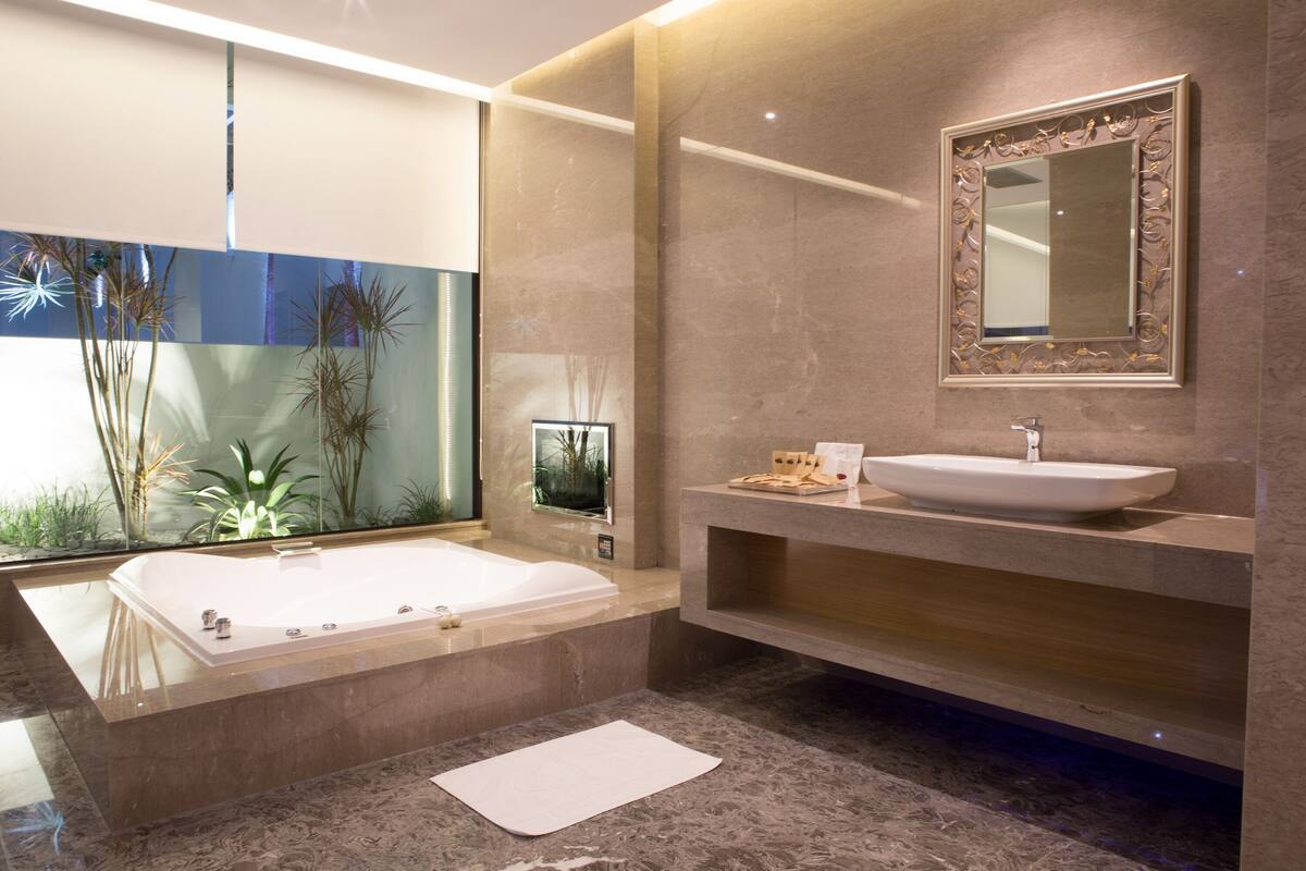 A modern bathroom with a freestanding bathtub, a large mirror, and a sink.