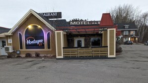 Ein Motel mit einem Neon-Schild für ein Restaurant namens 'Montagne 20' und einem Schild für 'Motel de la N'.