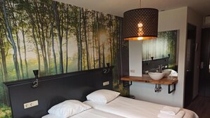 A bedroom with two beds, a nightstand, a wooden shelf with a sink, and a large mirror. - Hotel De Kruishoeve (Vught)