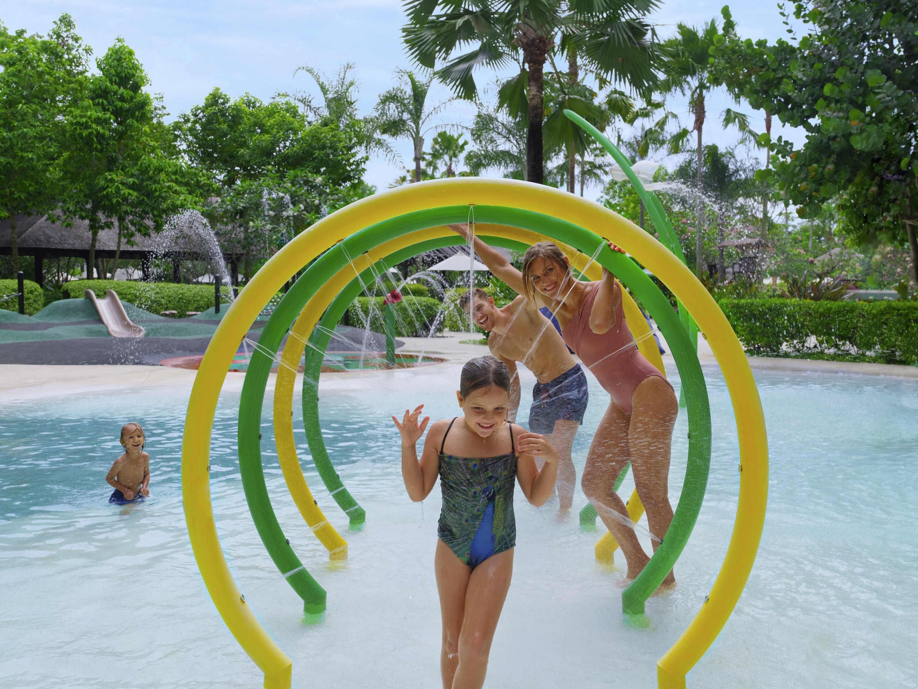 Een waterpark met een ronde waterspeelconstructie en een glijbaan op de achtergrond.