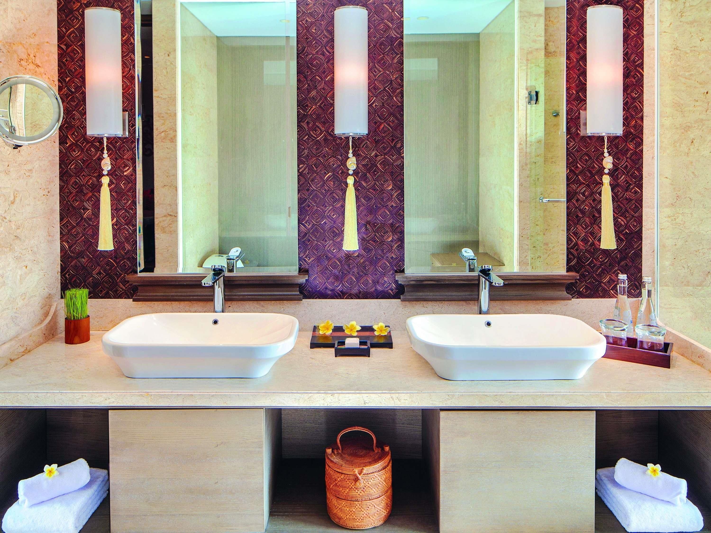 A bathroom with two sinks, a mirror, and a towel rack.