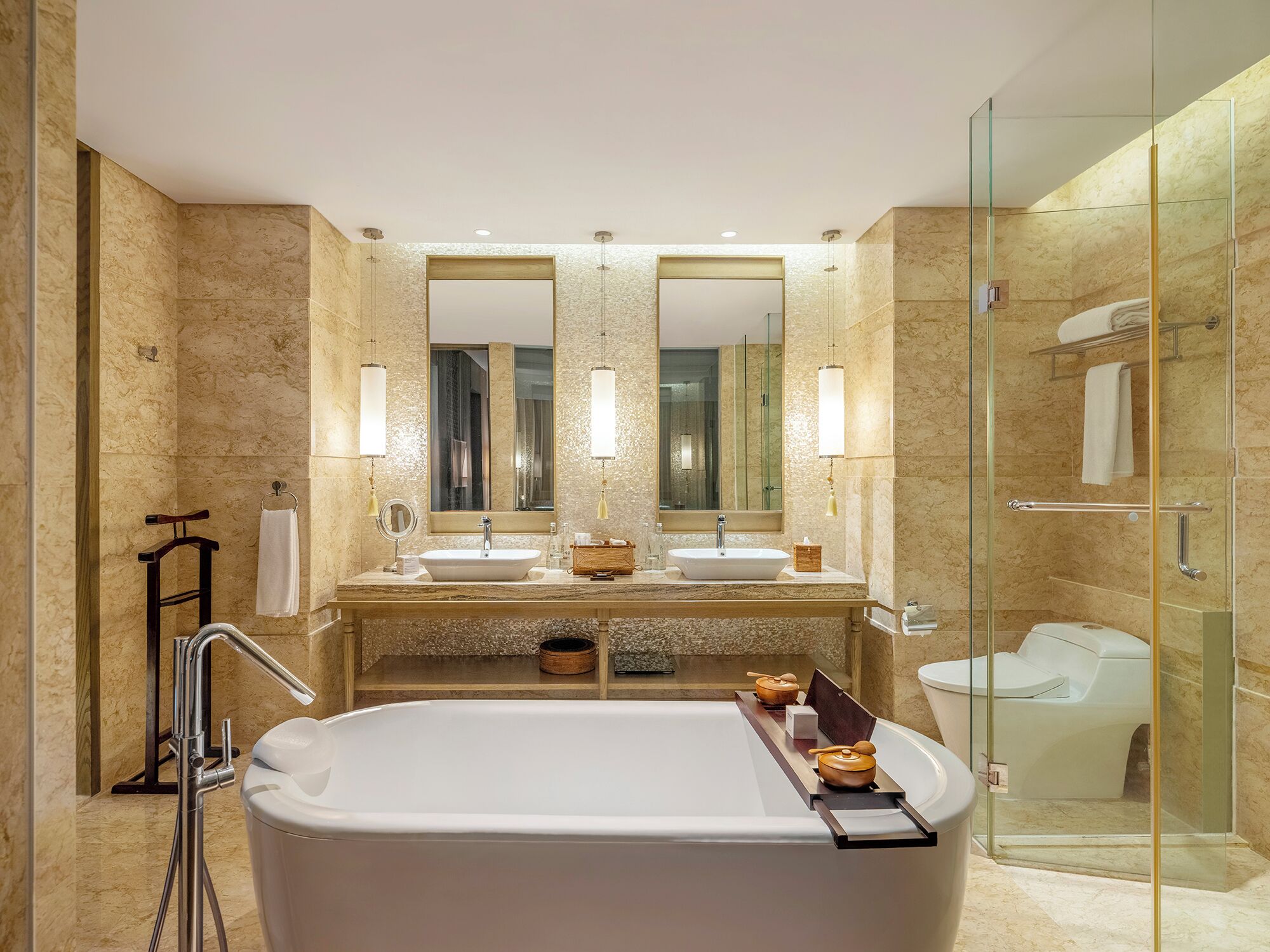 A modern bathroom with a large bathtub, two sinks, a glass-enclosed shower, and a large mirror.