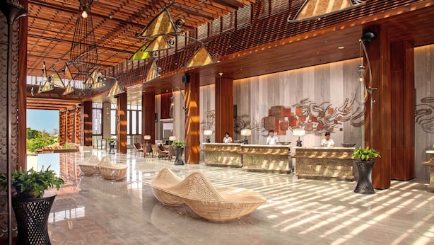 A spacious lobby with a wooden ceiling, a reception desk, and wicker seating. - Mövenpick Resort & Spa Jimbaran Bali (Jimbaran)