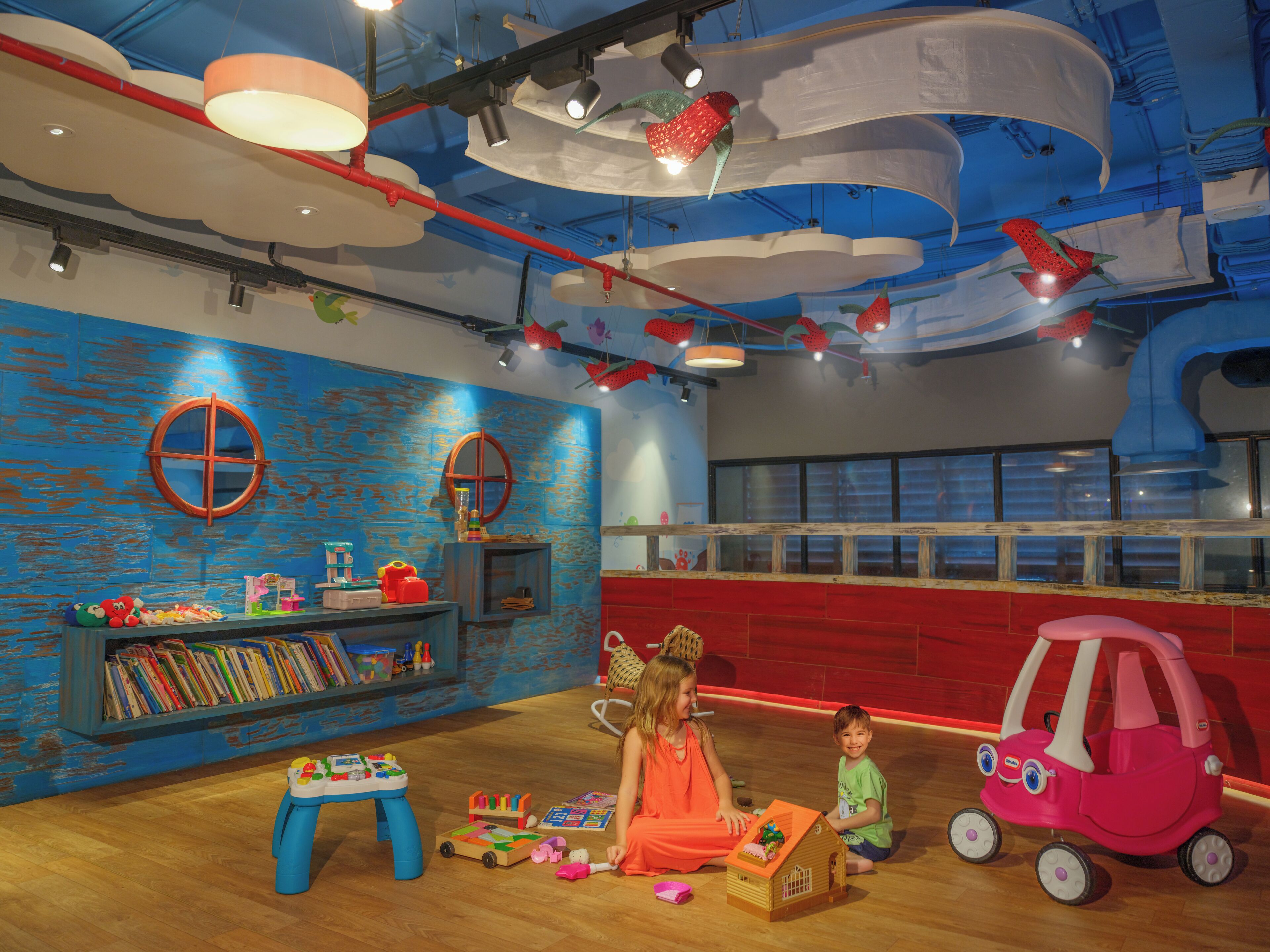 A children's play area with a bookshelf, a small table, and a toy car.
