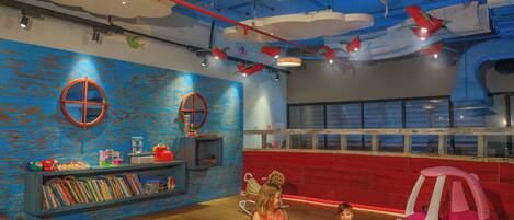 A children's play area with a bookshelf, a small table, and a toy car.