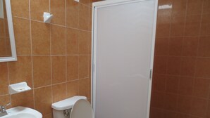 A bathroom with a toilet, sink, and mirror. - Hotel Arboledas (Talpa de Allende)