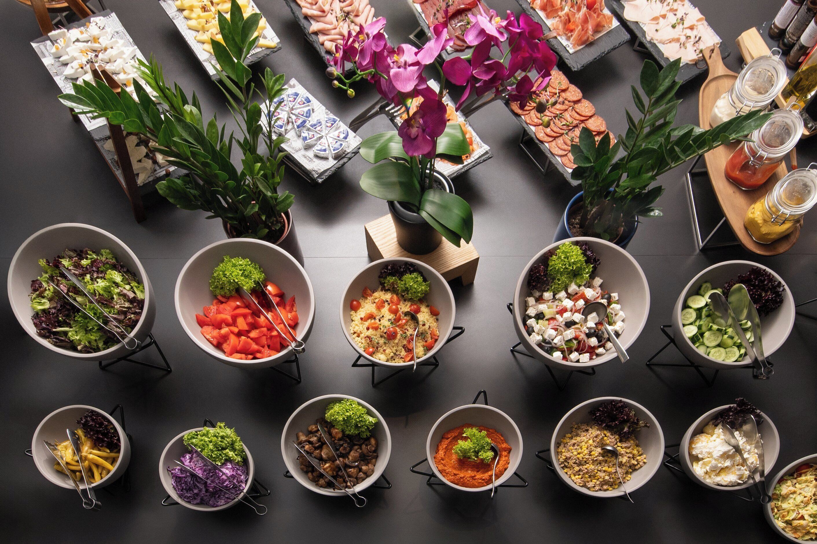 A variety of food items arranged on a table with multiple bowls and trays.