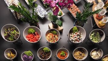 A variety of food items arranged on a table with multiple bowls and trays.