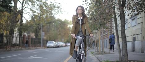 Una persona montando en bicicleta por una calle arbolada.