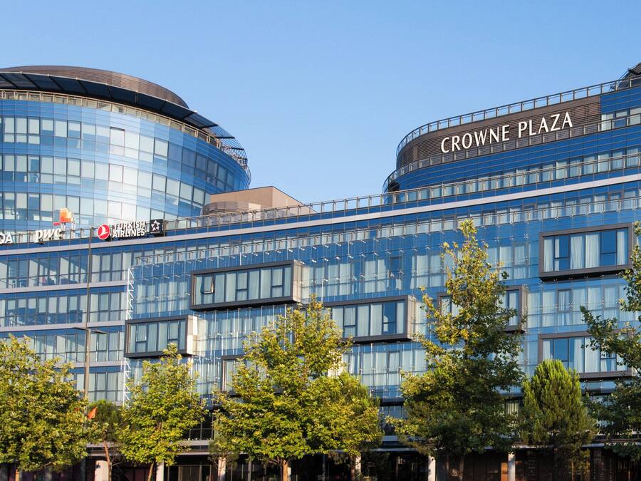 Un edificio moderno con il cartello 'CROWNE PLAZA' sulla sommità.