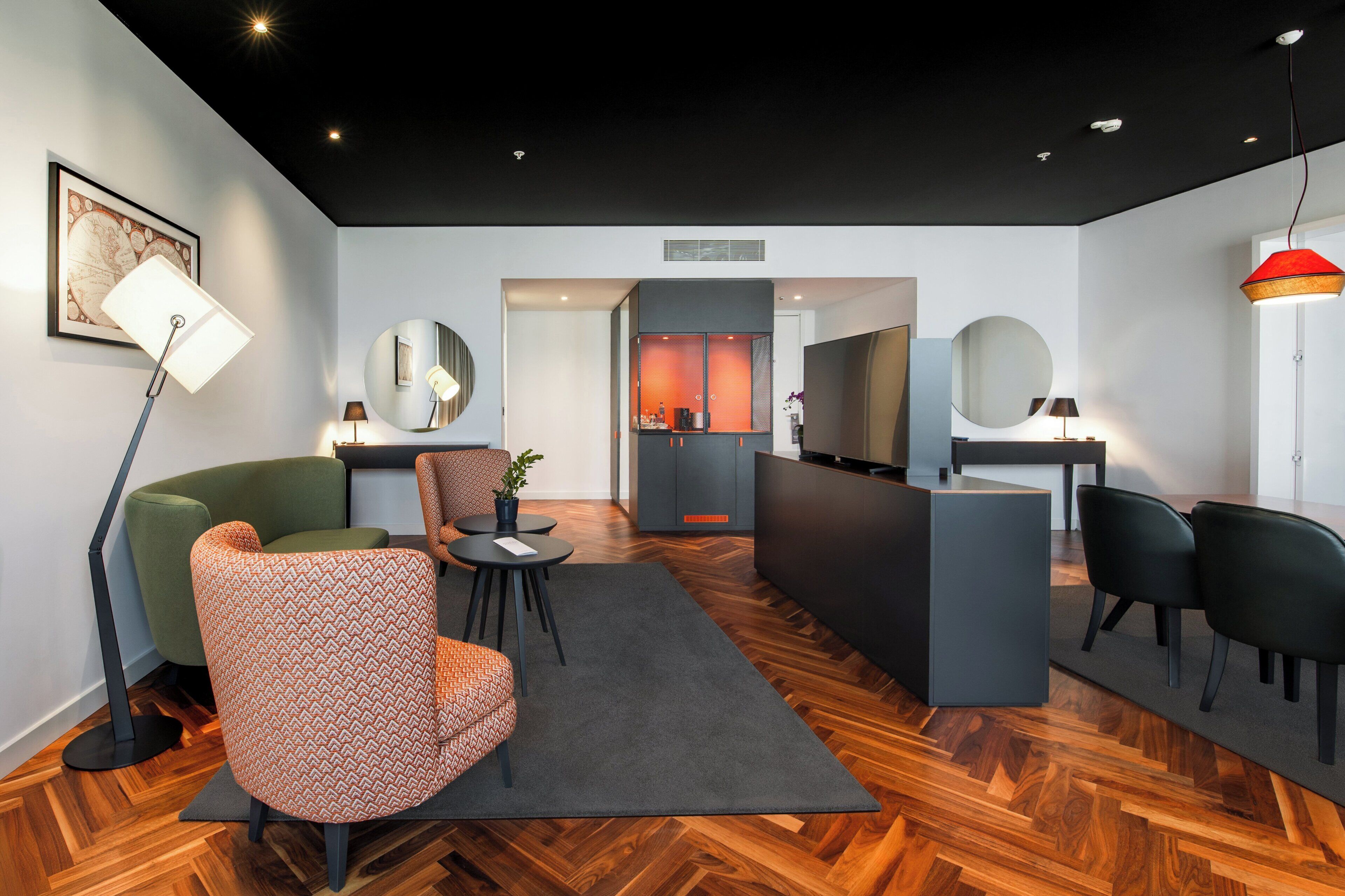 A modern hotel lobby with a wooden floor, a reception desk, and seating areas.