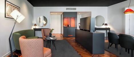 A modern hotel lobby with a wooden floor, a reception desk, and seating areas.
