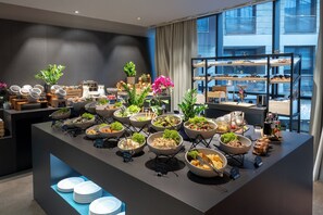 A buffet setup with various food items and a display of baked goods. - Crowne Plaza Podgorica by IHG (Podgorica)