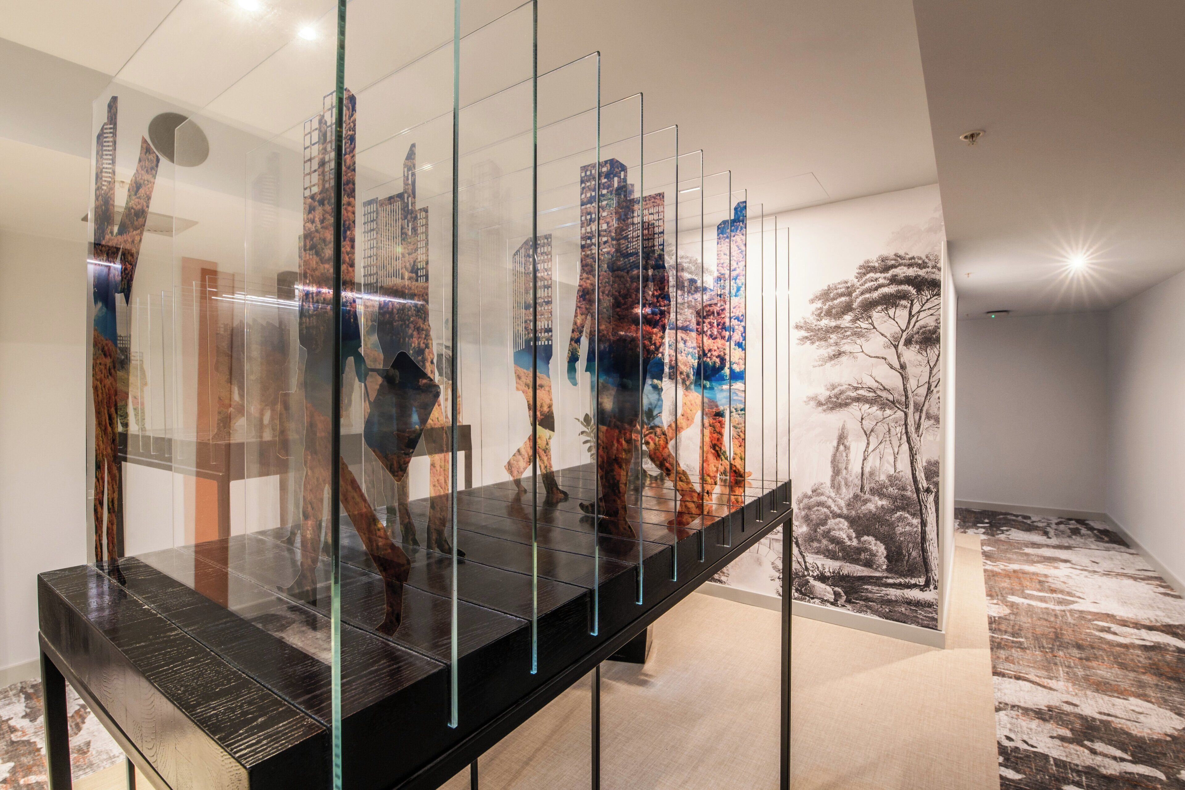 Une galerie d’art moderne où sont exposées des peintures et des sculptures abstraites sur une longue table.