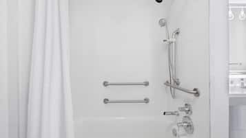 A modern bathroom with a walk-in shower, grab bars, and a handheld showerhead.