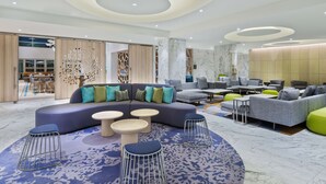 A modern lounge area with a curved seating arrangement, a marble floor, and a decorative ceiling. - Homewood Suites by Hilton Sarasota Lakewood Ranch (Sarasota)