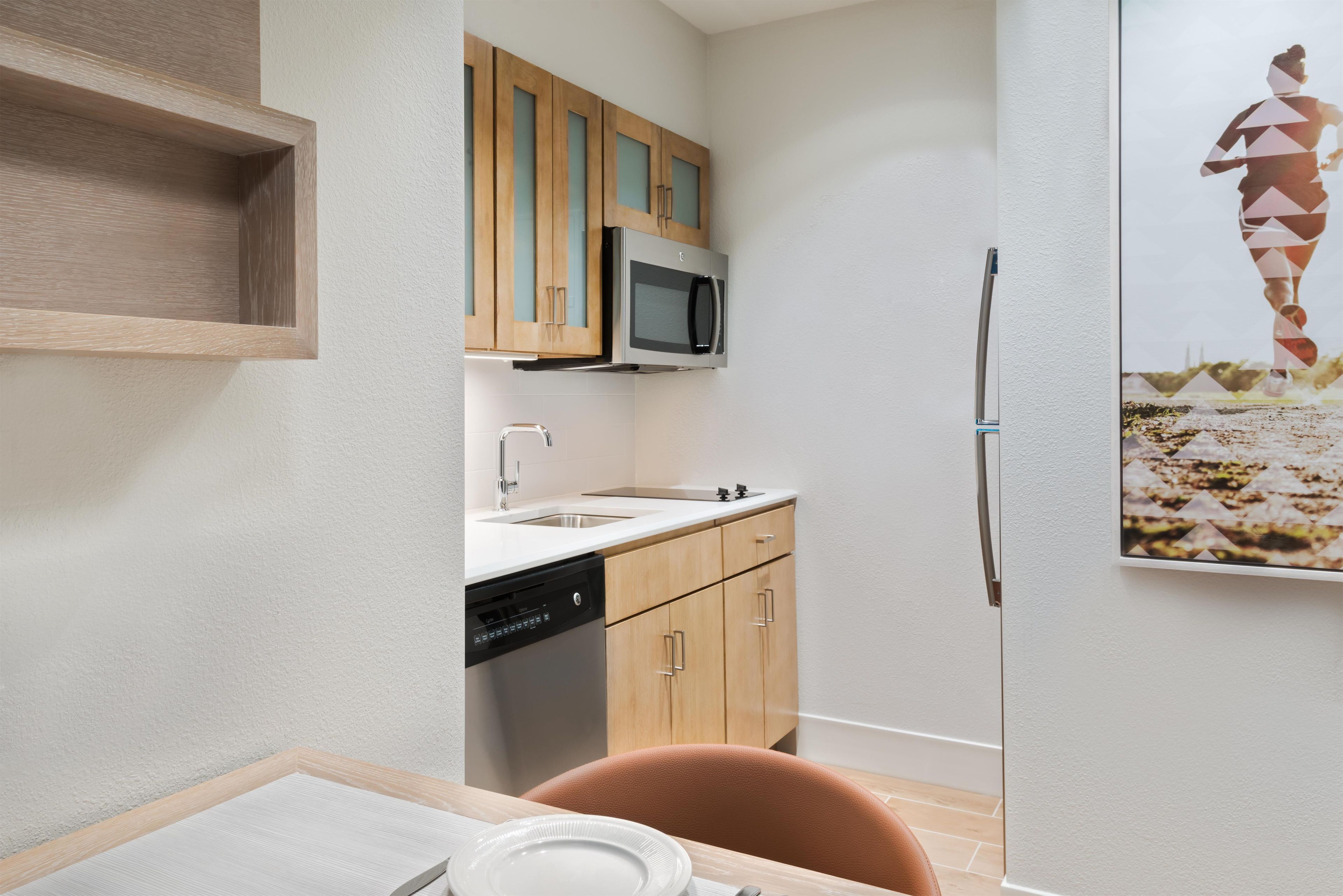 A compact kitchen with a microwave, dishwasher, and a refrigerator.
