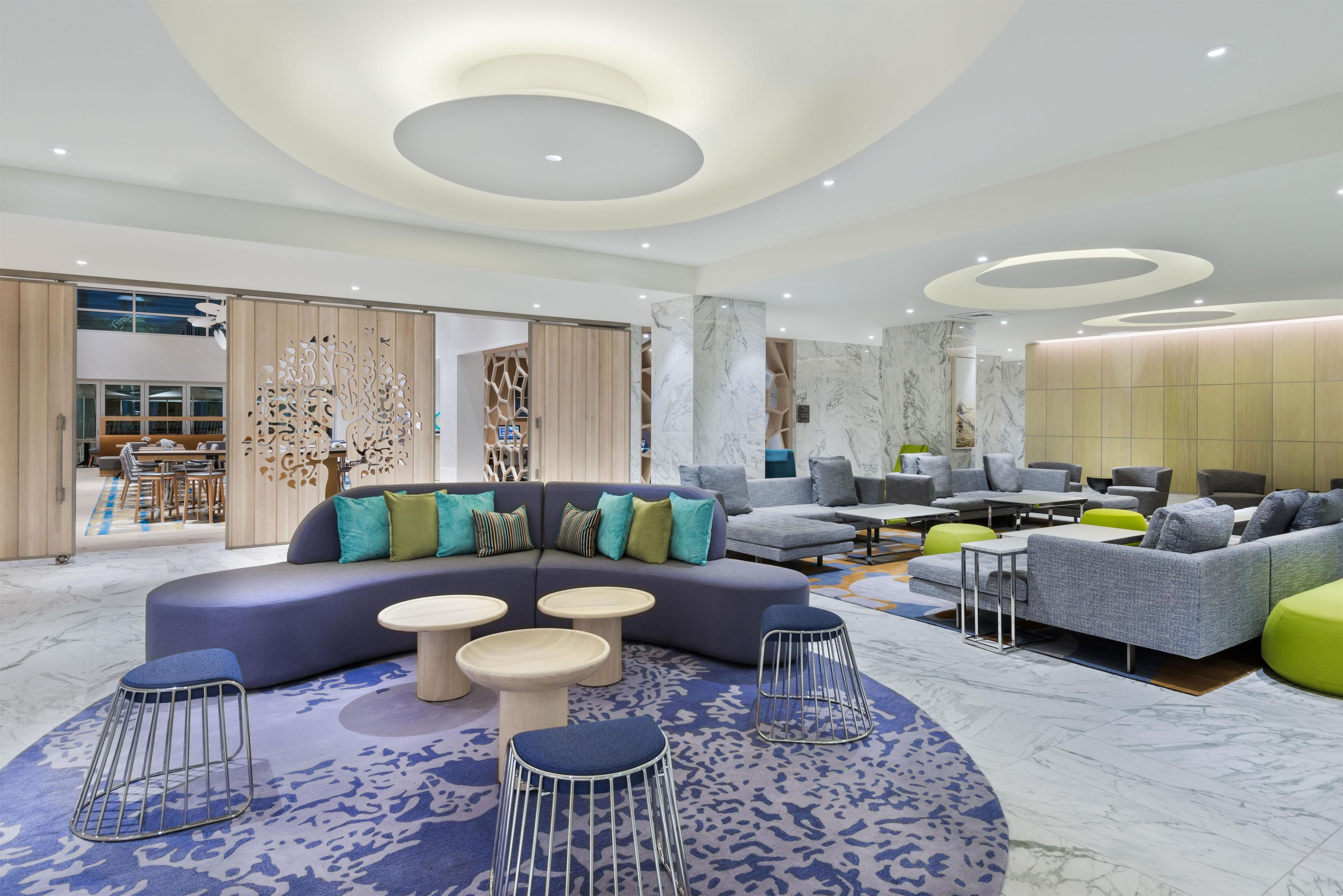 A modern interior with a sectional sofa, round tables, and a variety of seating options.