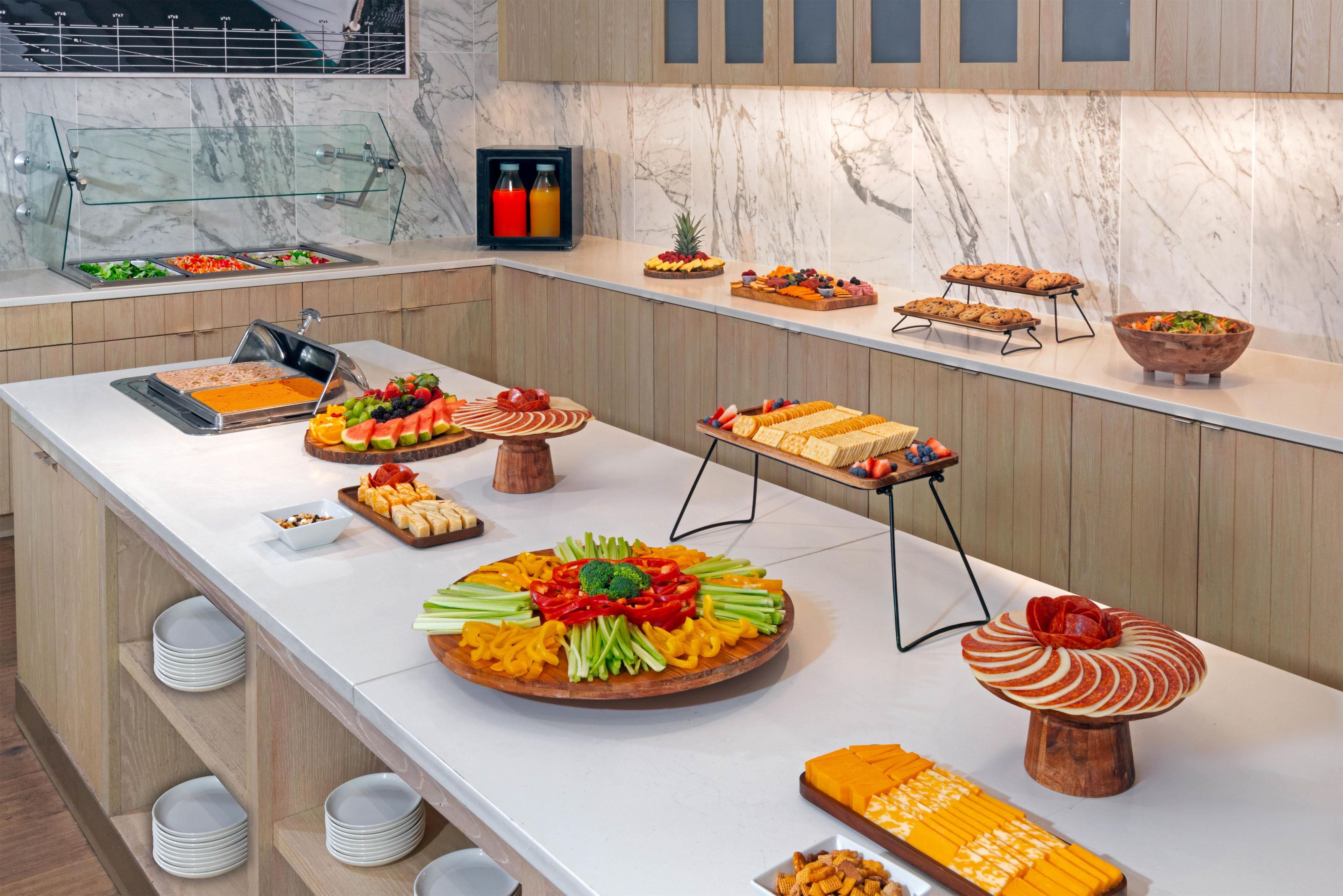 Un bufé con diversas opciones de comida y una presentación de frutas.