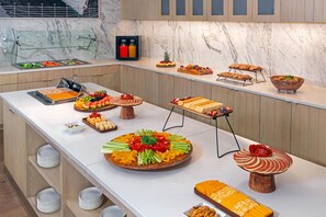 Un buffet proposant une variété de plats et une présentation de fruits.